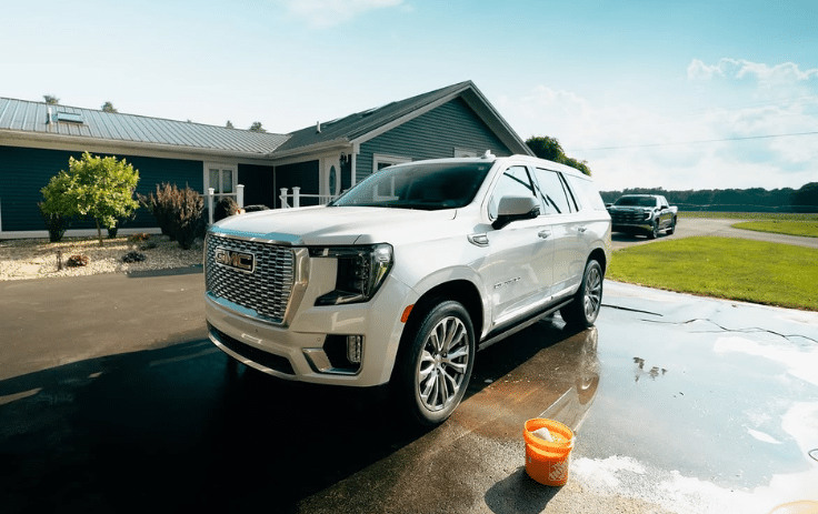 White SUV receiving mobile auto detailing at a home in Lansing, MI